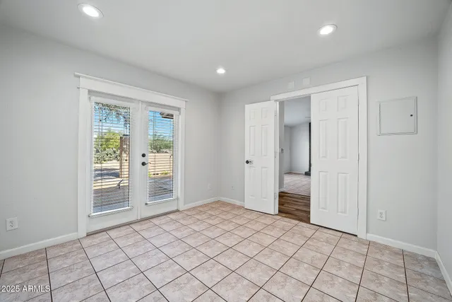 a view of an empty room with window and chandelier fan