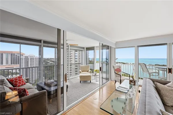 a living room with furniture and floor to ceiling windows