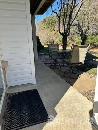 a view of backyard with seating space and trees