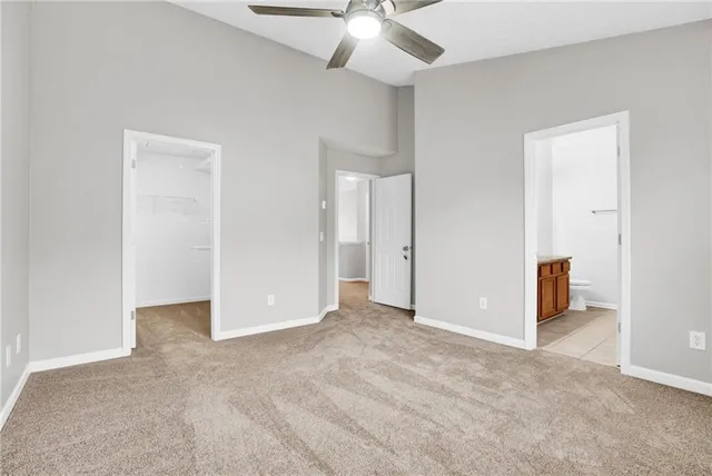 an empty room with closet and a ceiling fan