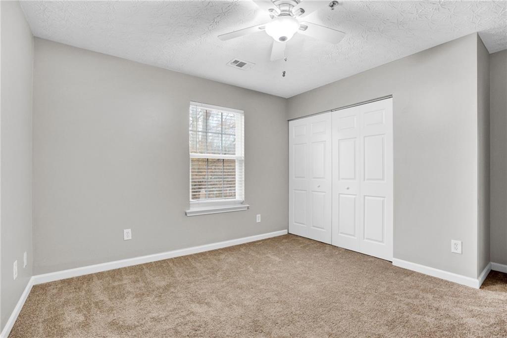241 Village Square Drive Woodstock, GA 30188 - Photo 21 of 40 an empty room with chandelier fan and windows