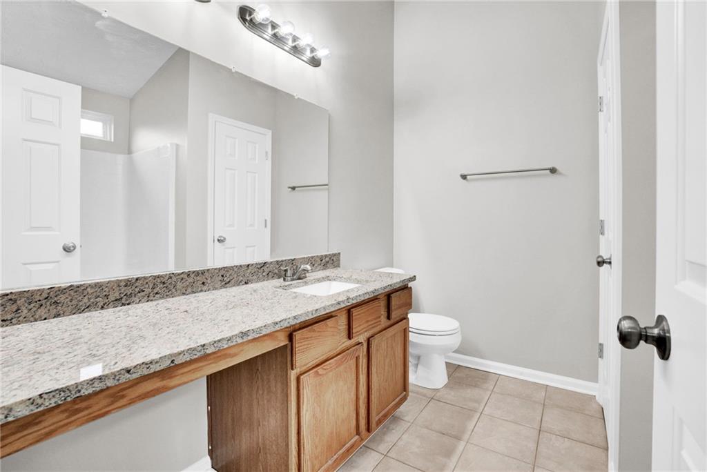 241 Village Square Drive Woodstock, GA 30188 - Photo 26 of 40 a bathroom with a granite countertop sink a toilet and a shower