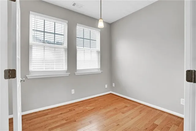 a view of a room with wooden floor and windows