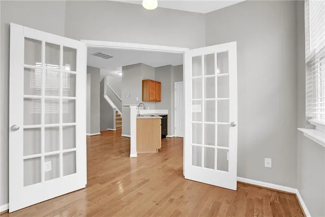a view of an empty room with a window and wooden floor