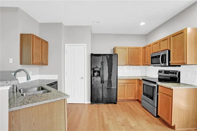 a kitchen with stainless steel appliances granite countertop a refrigerator stove microwave and sink