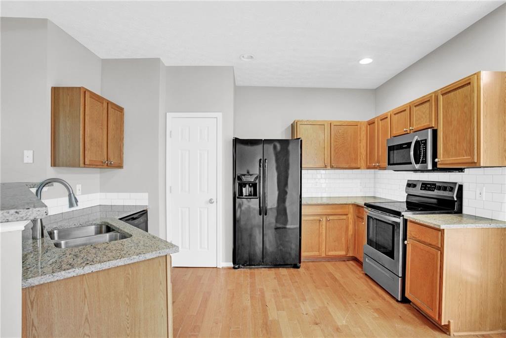 241 Village Square Drive Woodstock, GA 30188 - Photo 8 of 40 a kitchen with stainless steel appliances granite countertop a refrigerator stove microwave and sink