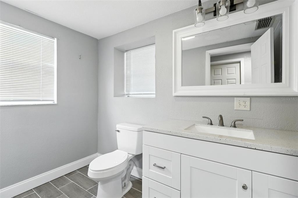 8035 Gulf Way Hudson, FL 34667 - Photo 16 of 26 a bathroom with a toilet sink and mirror