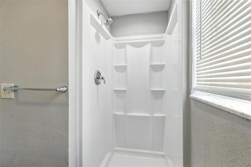 8035 Gulf Way Hudson, FL 34667 - Photo 17 of 26 a bathroom with a glass shower door