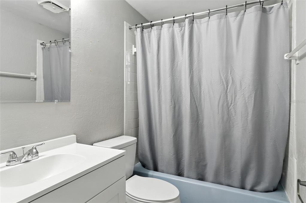 8035 Gulf Way Hudson, FL 34667 - Photo 20 of 26 a bathroom with a sink a toilet and shower curtain
