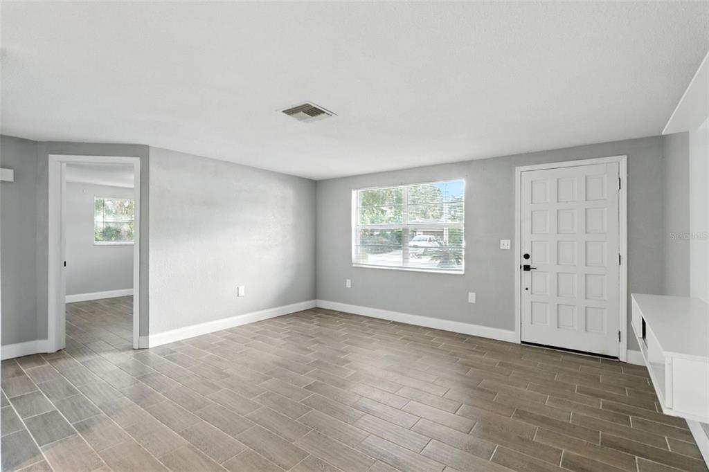 8035 Gulf Way Hudson, FL 34667 - Photo 8 of 26 a view of an empty room with wooden floor and a window
