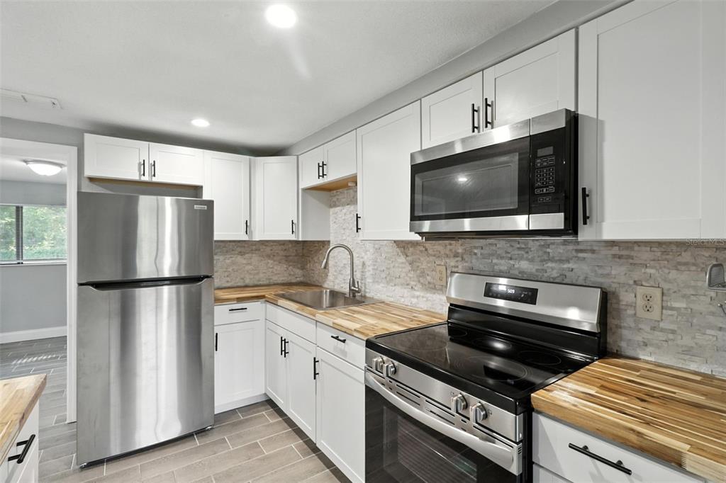 8035 Gulf Way Hudson, FL 34667 - Photo 10 of 26 a kitchen with a refrigerator stove and microwave