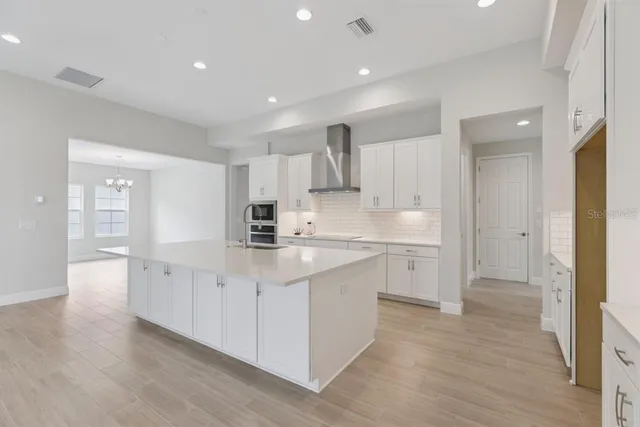 a kitchen with white cabinets appliances and a sink