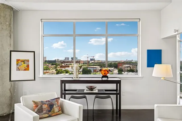 a living room with fireplace furniture and a large window