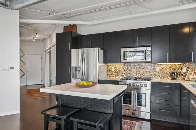 a kitchen with a sink a refrigerator and chairs