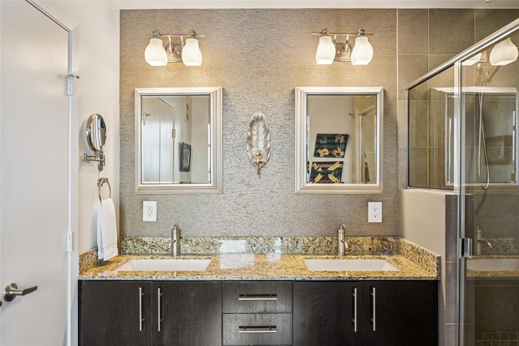 1001 Belleview Street, Unit 708 Dallas, TX 75215 - Photo 19 of 40 a bathroom with a granite countertop sink a mirror and a shower