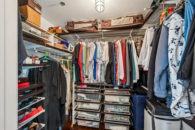 a view of walk in closet with clothes and shoes