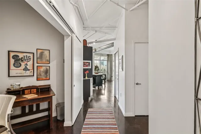 a view of a hallway with wooden floor and a workspace