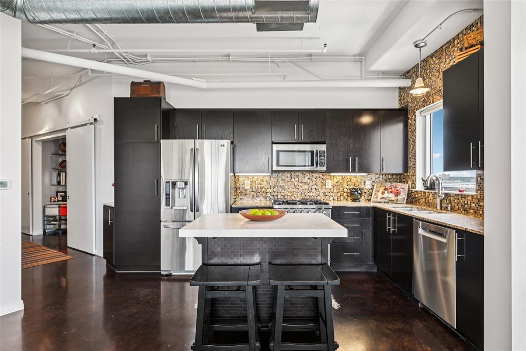 1001 Belleview Street, Unit 708 Dallas, TX 75215 - Photo 4 of 40 a large kitchen with a table and chairs