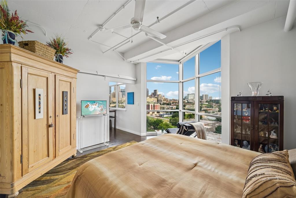 1001 Belleview Street, Unit 708 Dallas, TX 75215 - Photo 7 of 40 a bedroom with a bed dresser and a large mirror