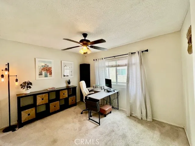 an empty room with windows and fan