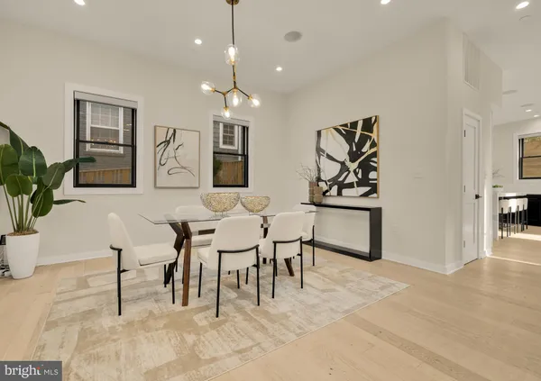 a view of a a dining room with furniture window and wooden floor
