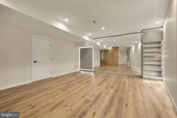 a view of empty room with wooden floor