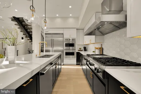 a kitchen with stainless steel appliances granite countertop a stove a sink dishwasher and a refrigerator with wooden floor