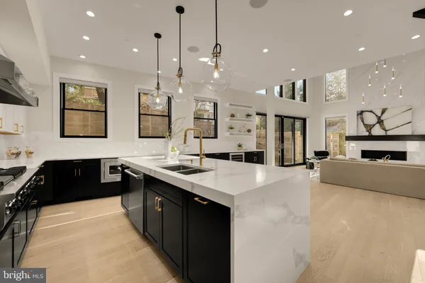 a spacious kitchen with stainless steel appliances granite countertop a sink a stove and a refrigerator