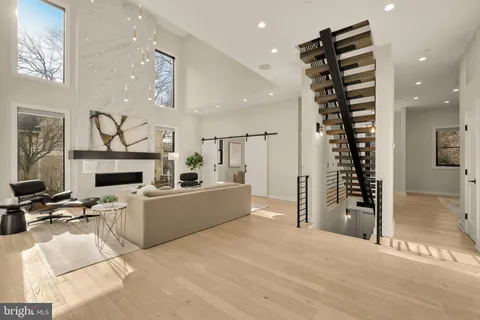 a living room with furniture a fireplace and a chandelier