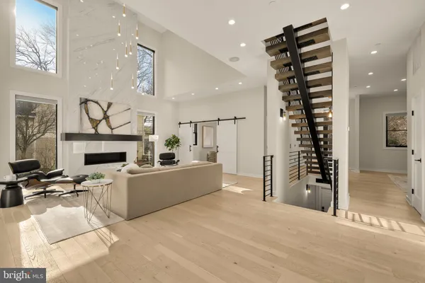 a living room with furniture a fireplace and a chandelier