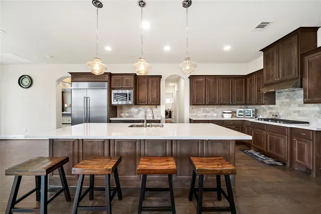 a large kitchen with a table and chairs