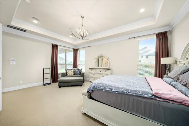 a spacious bedroom with a bed and a chandelier