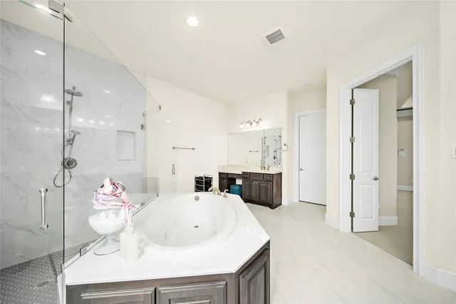 a bathroom with a tub sink shower and mirror