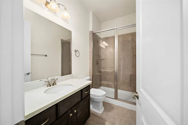 a spacious bathroom with a shower sink mirror and toilet
