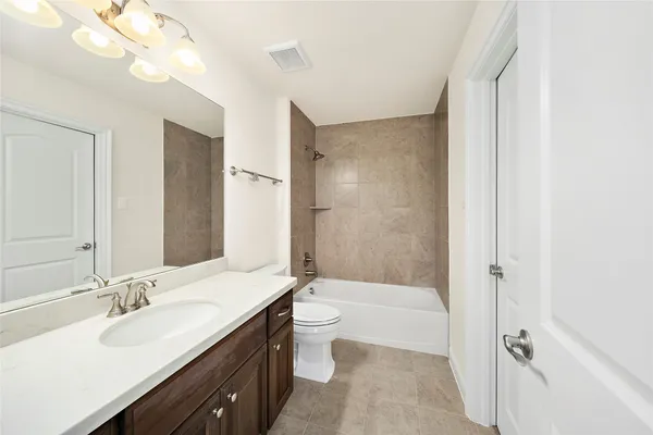 a bathroom with a double vanity sink toilet mirror and bathtub