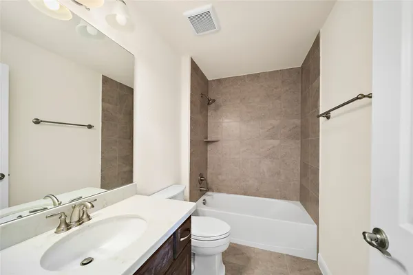 a bathroom with a sink a toilet and shower a mirror