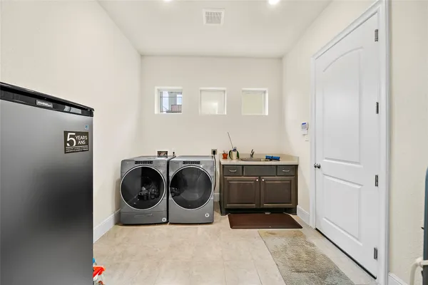 a utility room with cabinets dryer and washer