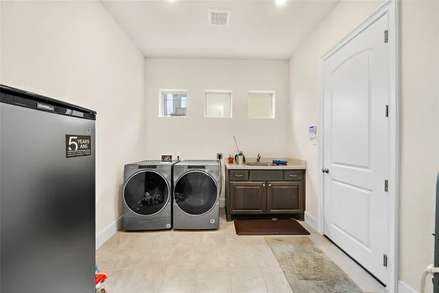 a utility room with cabinets dryer and washer