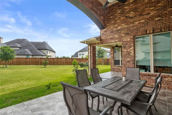 a view of a patio with table and chairs potted plants with wooden floor and fence