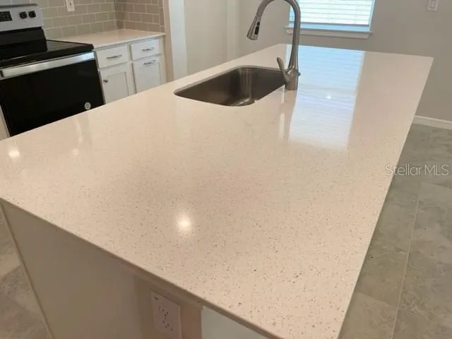 a kitchen with white cabinets appliances and sink