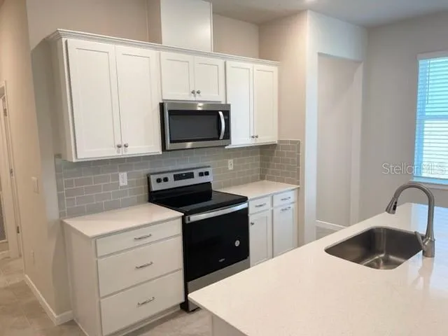 a kitchen with stainless steel appliances a microwave sink and refrigerator