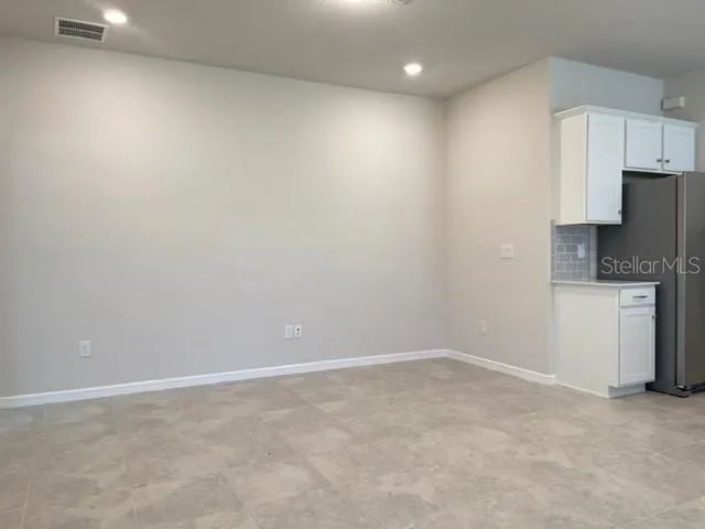 a view of kitchen with refrigerator cabinets and wooden floor