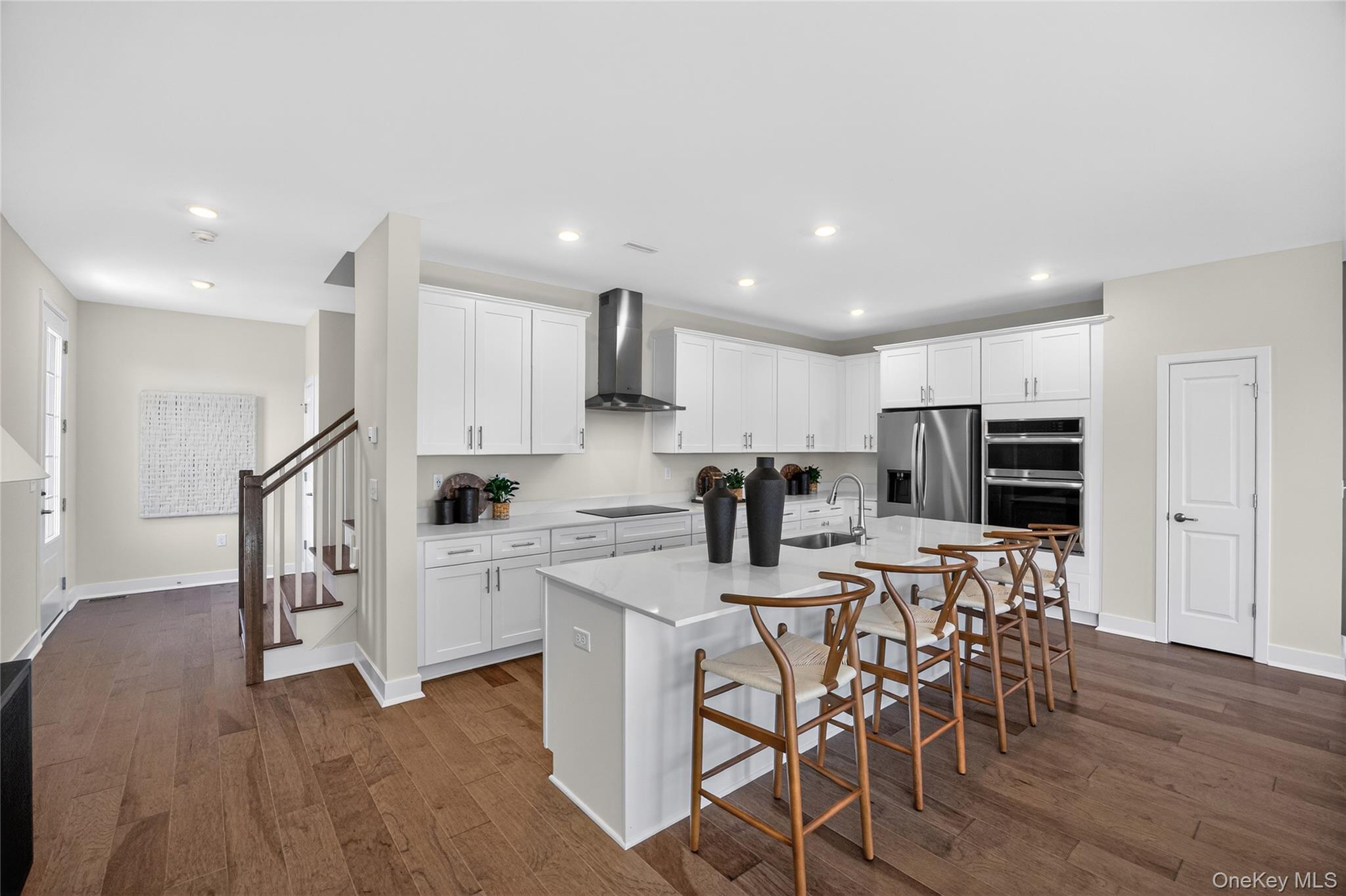 101 Pine Ridge Road Tuxedo Park, NY 10987 - Photo 6 of 26 Open-concept kitchen featuring white cabinetry, stainless steel appliances, and a large island with seating.