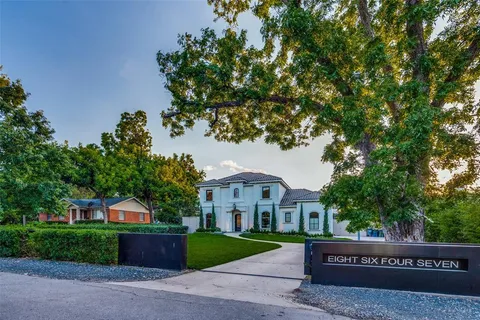 a front view of a house with a yard and tree