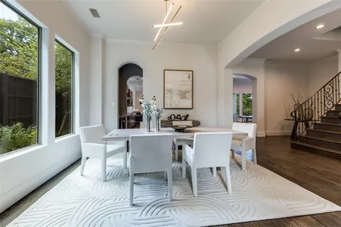 a dining room with wooden floor and a large window