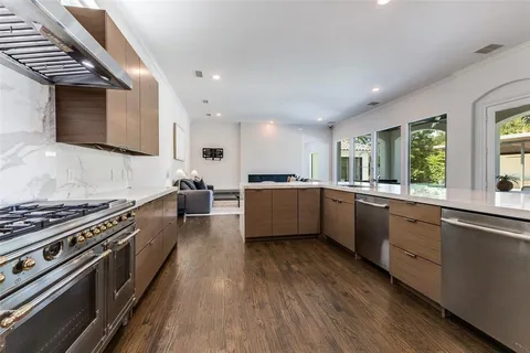 a large kitchen with stainless steel appliances granite countertop a stove and a sink