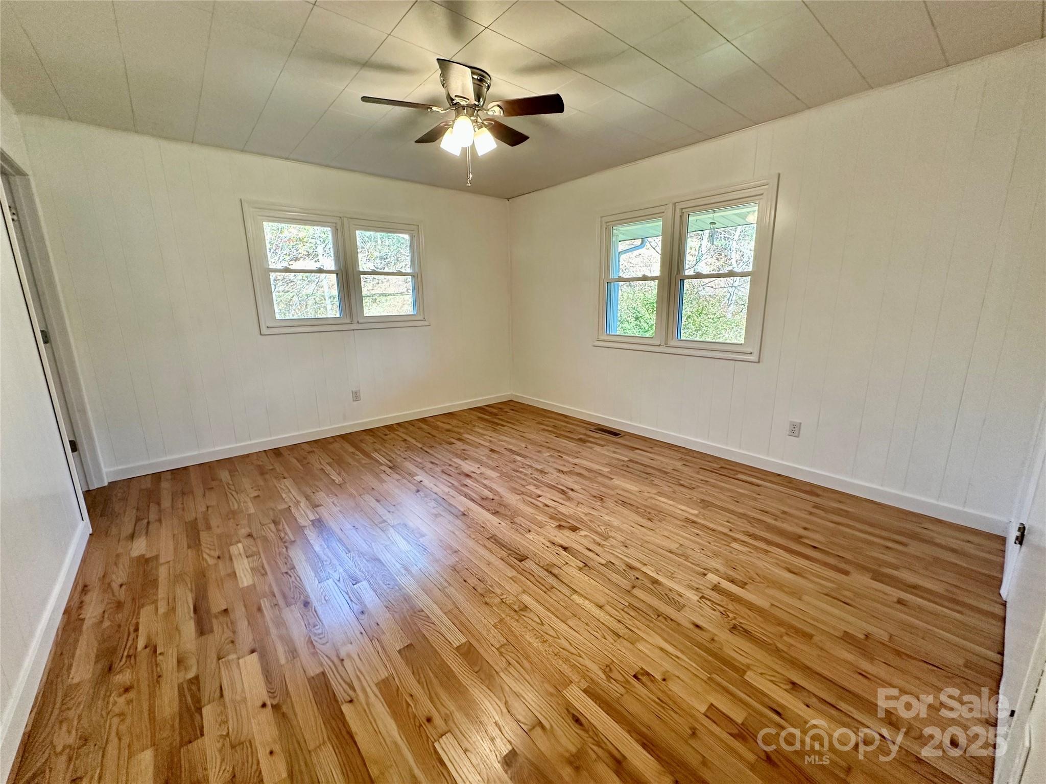 208 Murdock Road Bakersville, NC 28705 - Photo 11 of 32 a view of an empty room with a window and wooden floor