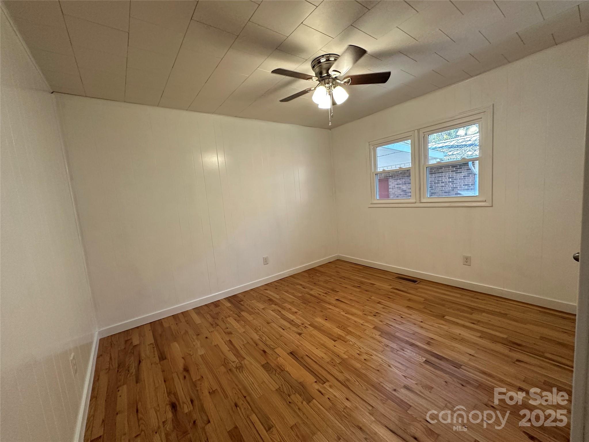 208 Murdock Road Bakersville, NC 28705 - Photo 12 of 32 a view of an empty room with wooden floor and chandelier