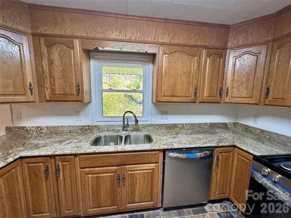 a kitchen with stainless steel appliances granite countertop a sink stove and cabinets