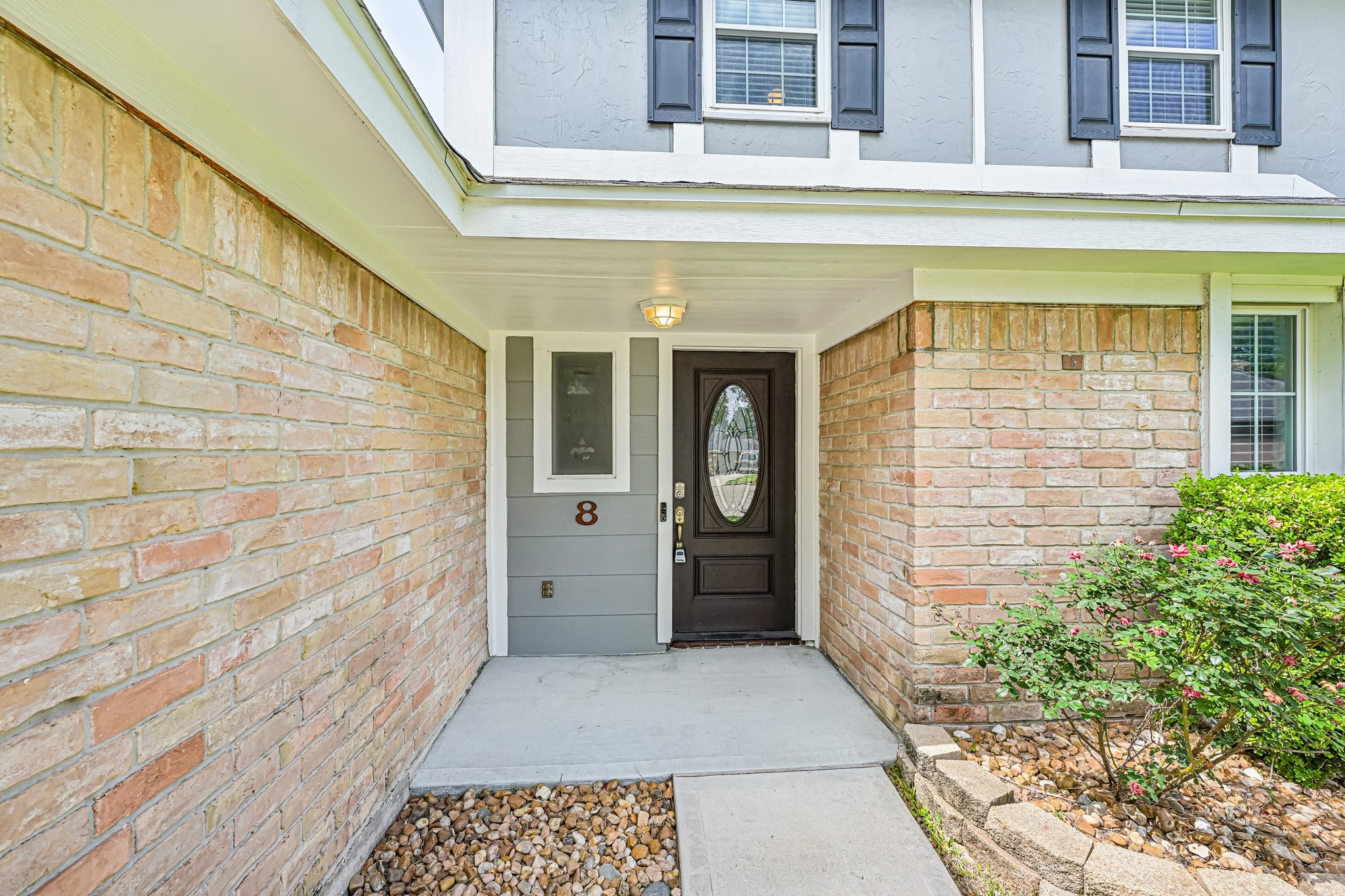 8 Arlington Street Conroe, TX 77301 - Photo 10 of 37 Welcoming entrance with a brick exterior, a stylish front door, and a small landscaped area with greenery, creating a charming and inviting curb appeal.